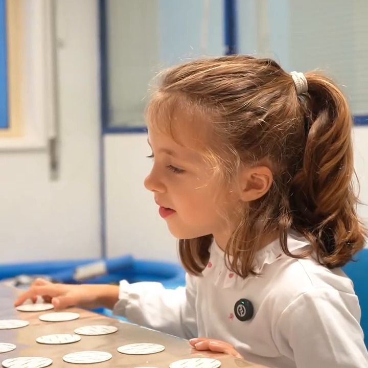 Uma menina a jogar um jogo de memória com cartões, durante uma sessão de Terapia da Fala