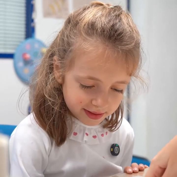 Uma menina sorridente durante uma sessão de Terapia da Fala